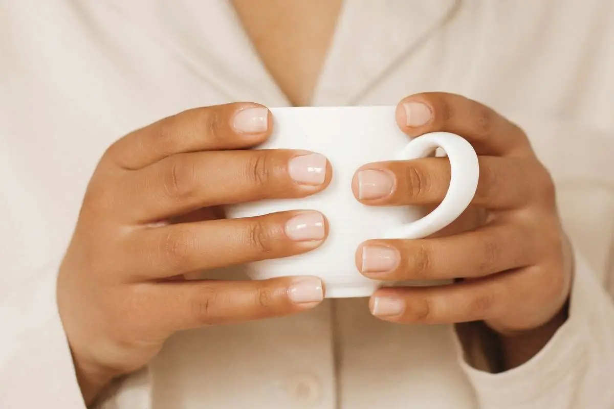 woman holding white coffee mug