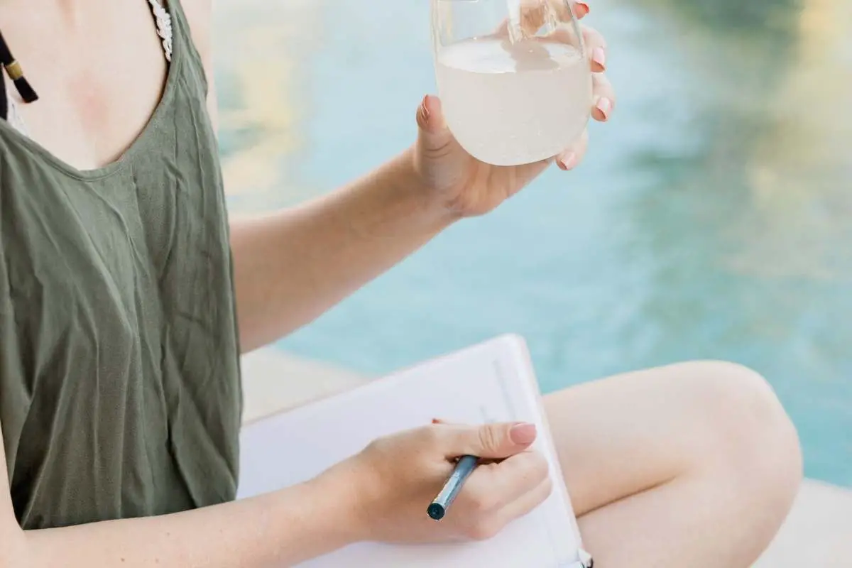 woman drinking water while planning