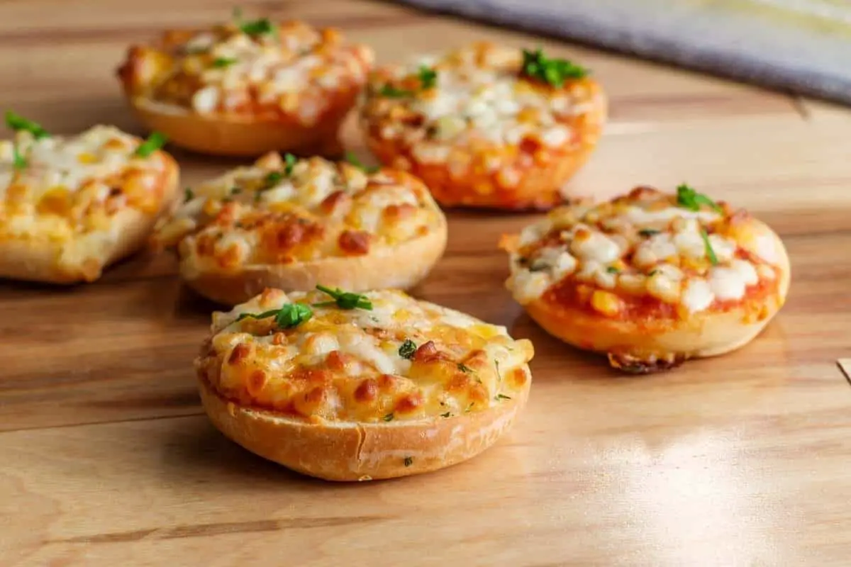 mini bagel pizzas on cutting board